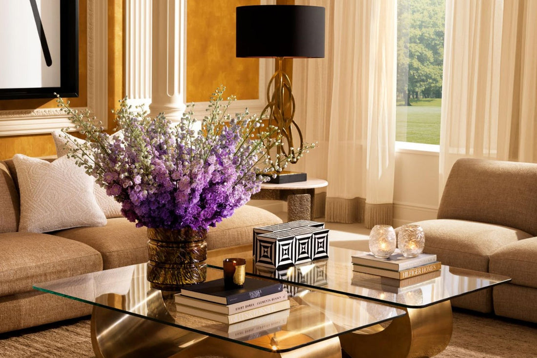 Elegantes Wohnzimmer mit goldenem Couchtisch und lila Blumen