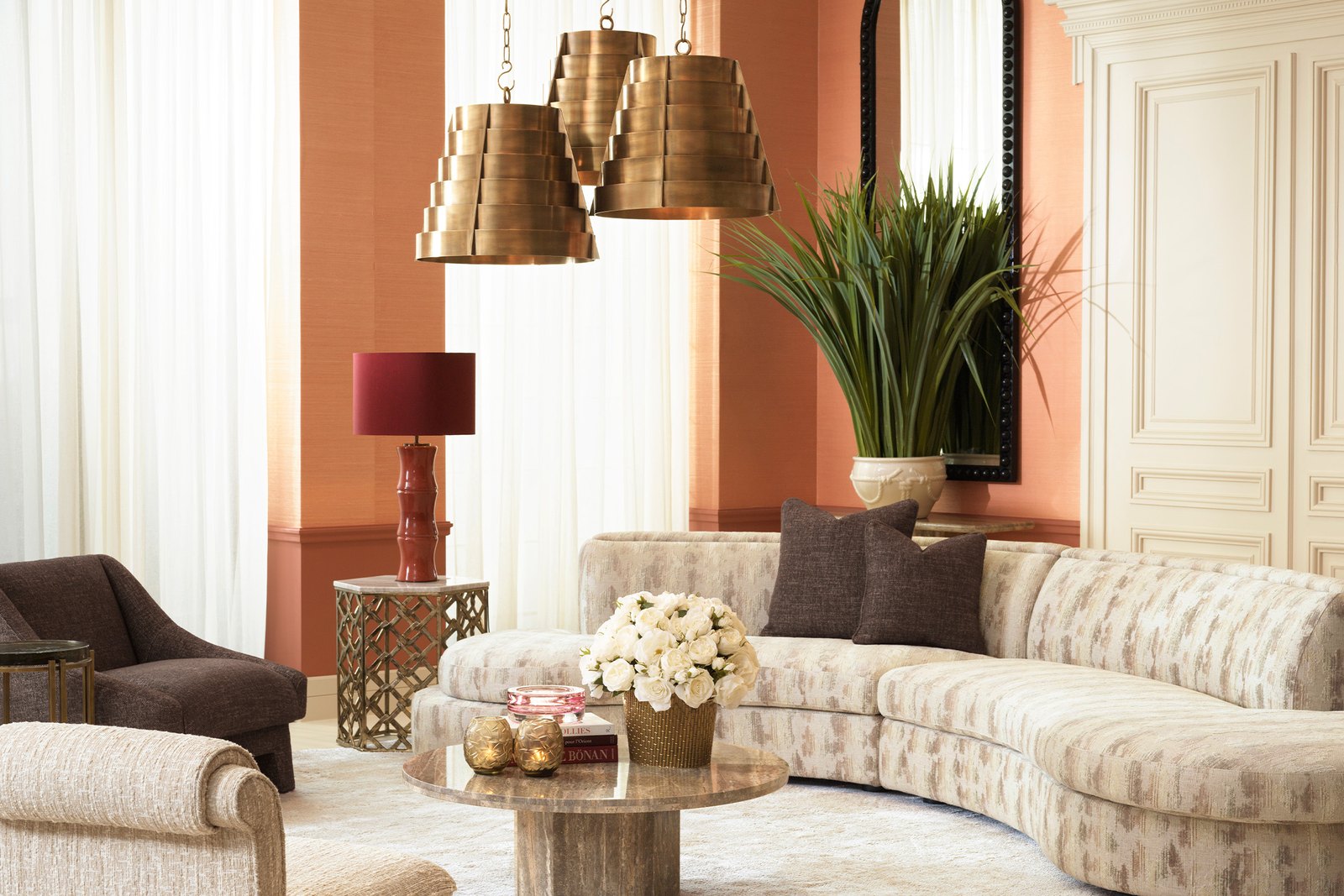 Elegantes Wohnzimmer mit geschwungenem Sofa und Pendelleuchten