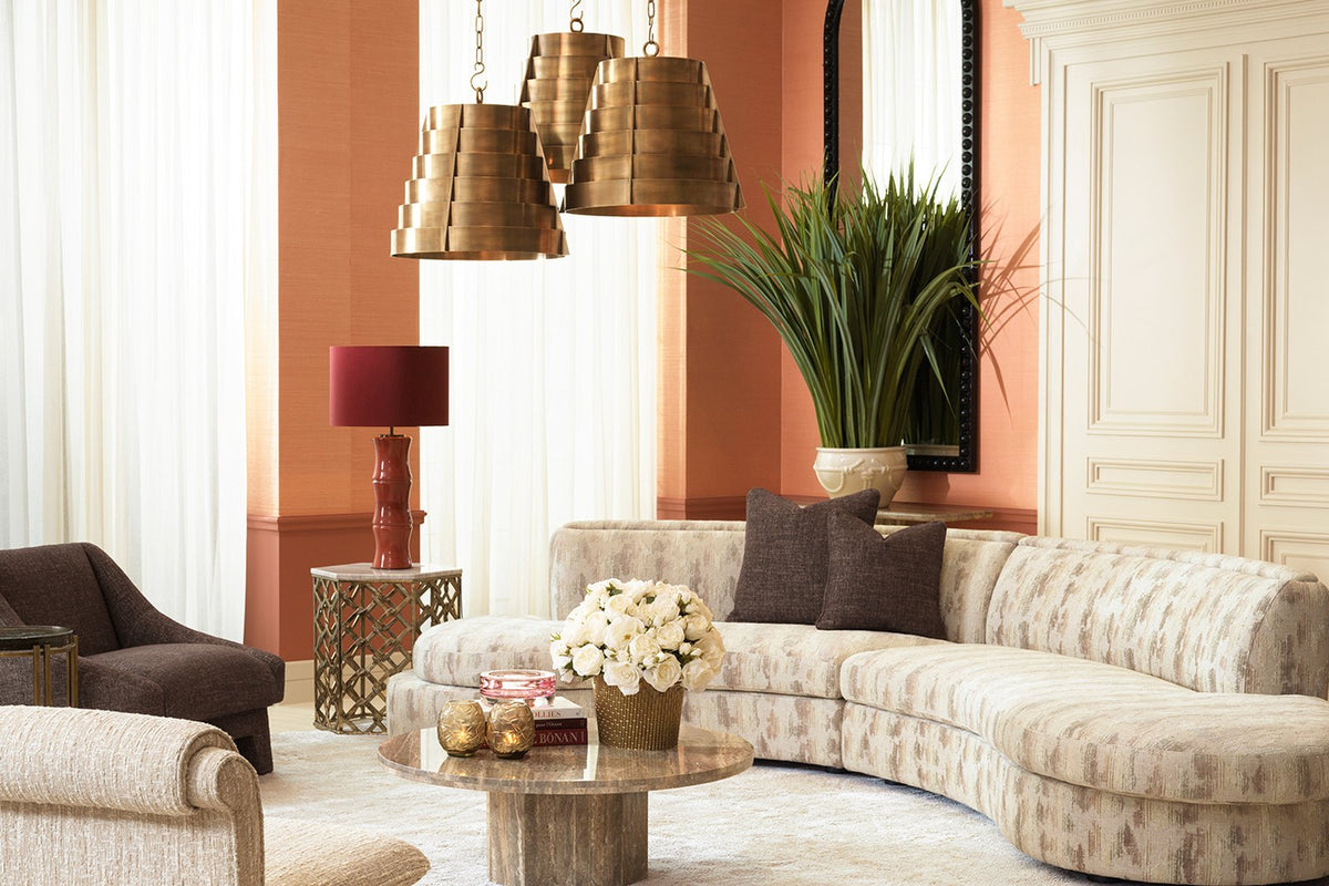 Elegantes Wohnzimmer mit geschwungenem Sofa und Messinglampen